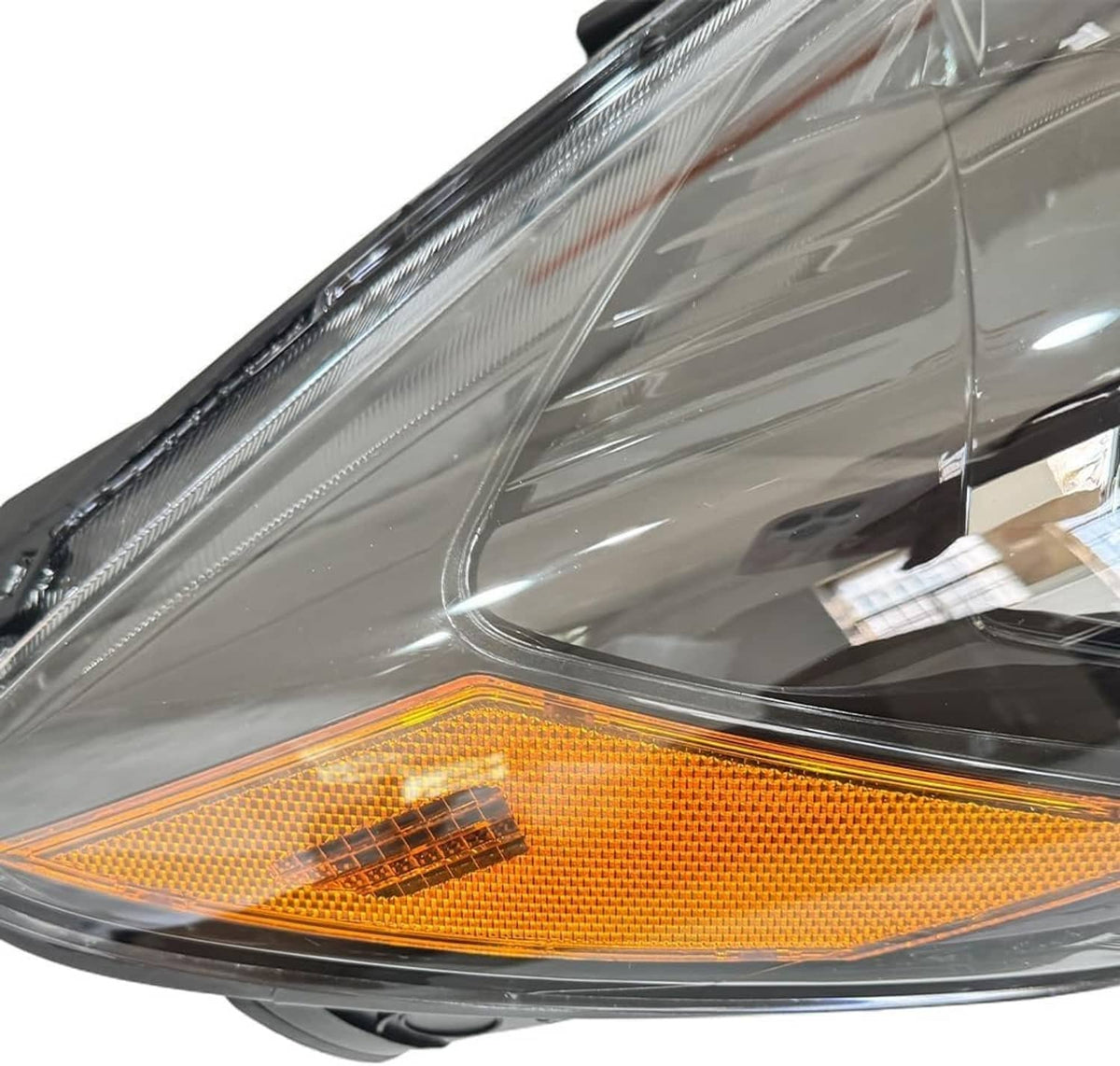 Right-side halogen headlight close-up of amber side marker and clear outer lens