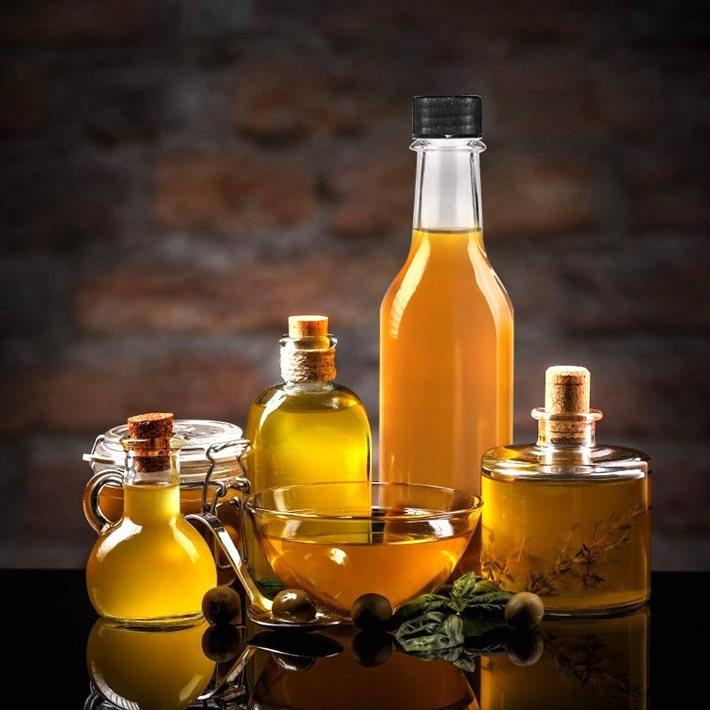 Glass hot sauce bottles with black caps and smaller oil bottles in a serving tray