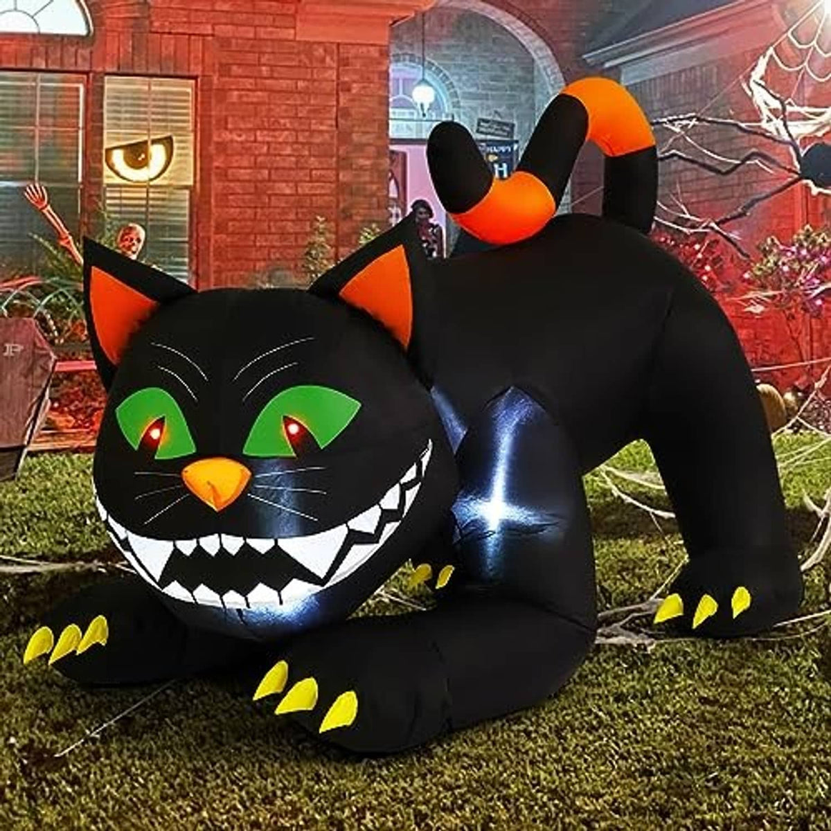 Inflatable black cat yard decoration with orange ears, green eyes, and open-mouthed grin