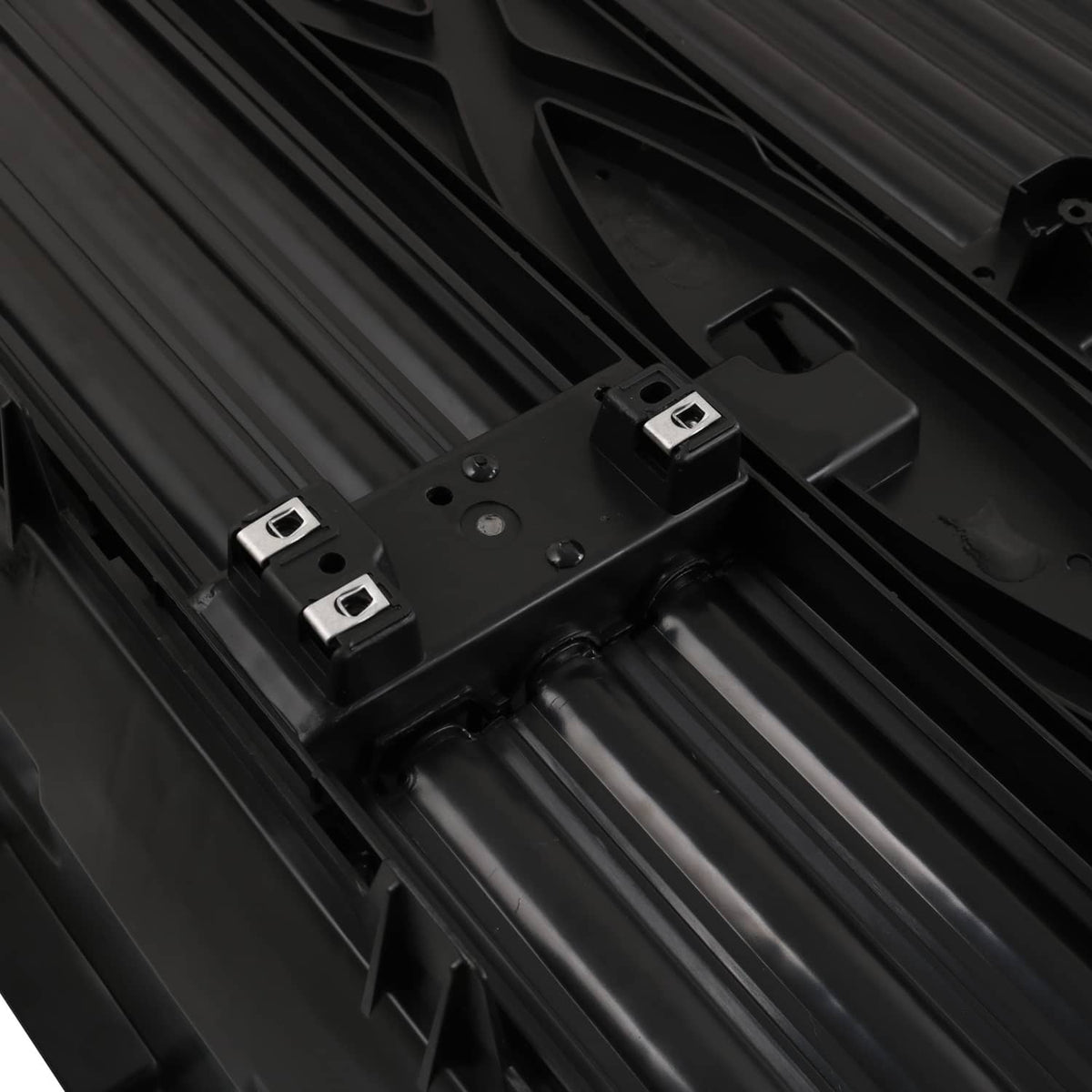 Close-up of black active grille shutter motor mounts with metal fasteners on frame