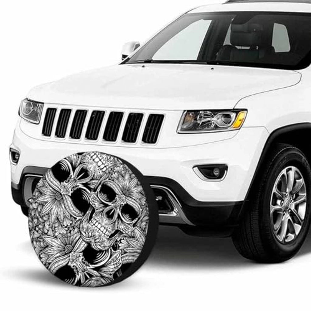 Skull wheel cover on front of white SUV, black-and-white ornate skull artwork