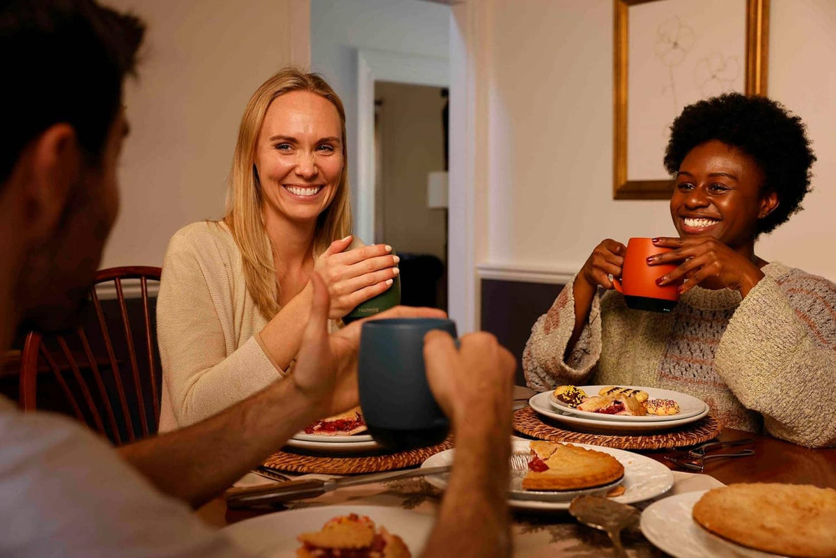 Self-heating coffee mug held on a dining table during a casual meal