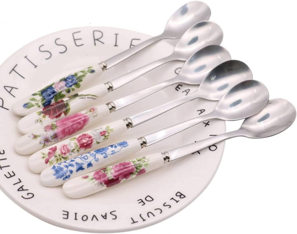 6 stainless steel teaspoons with white ceramic handles, floral designs on spoon stems