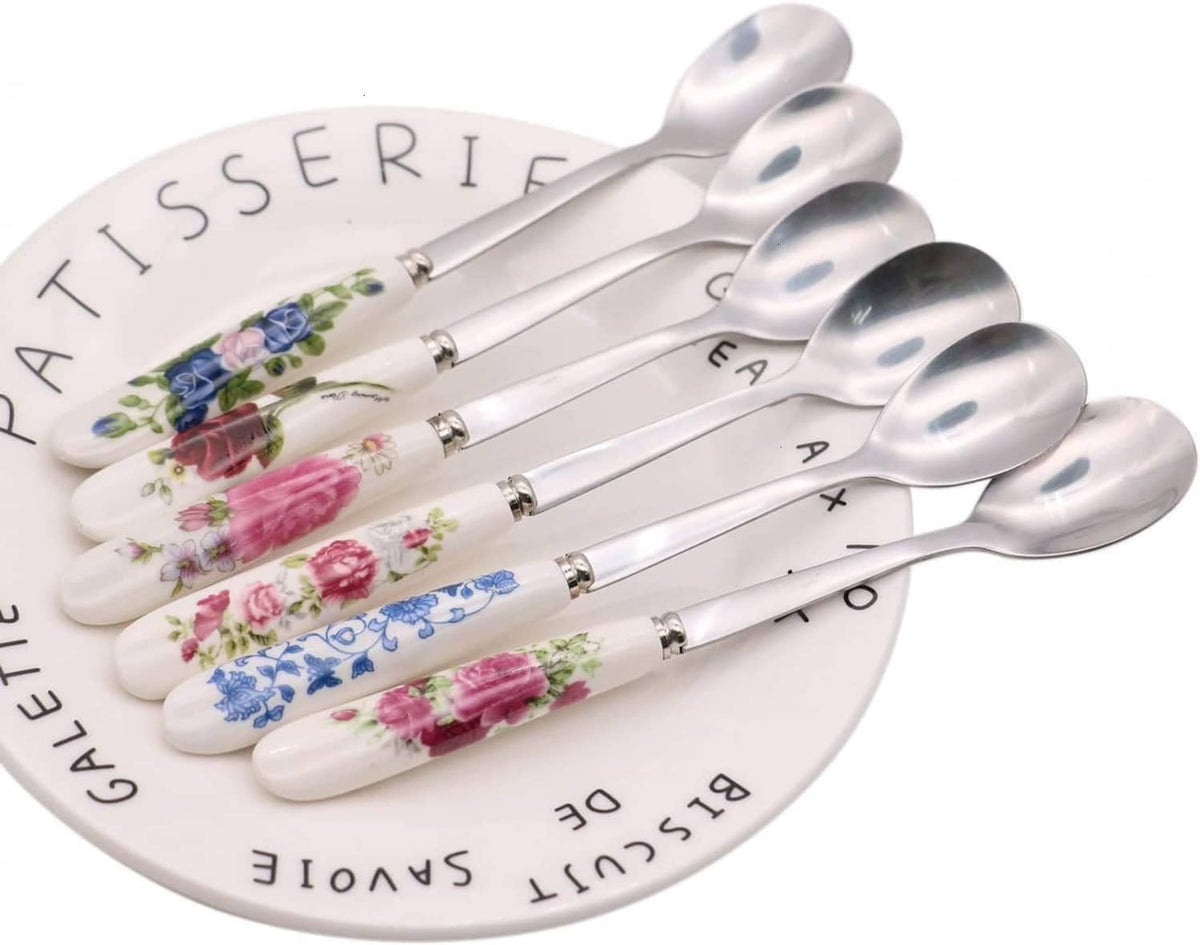 6 stainless steel teaspoons with white ceramic handles, floral designs on spoon stems