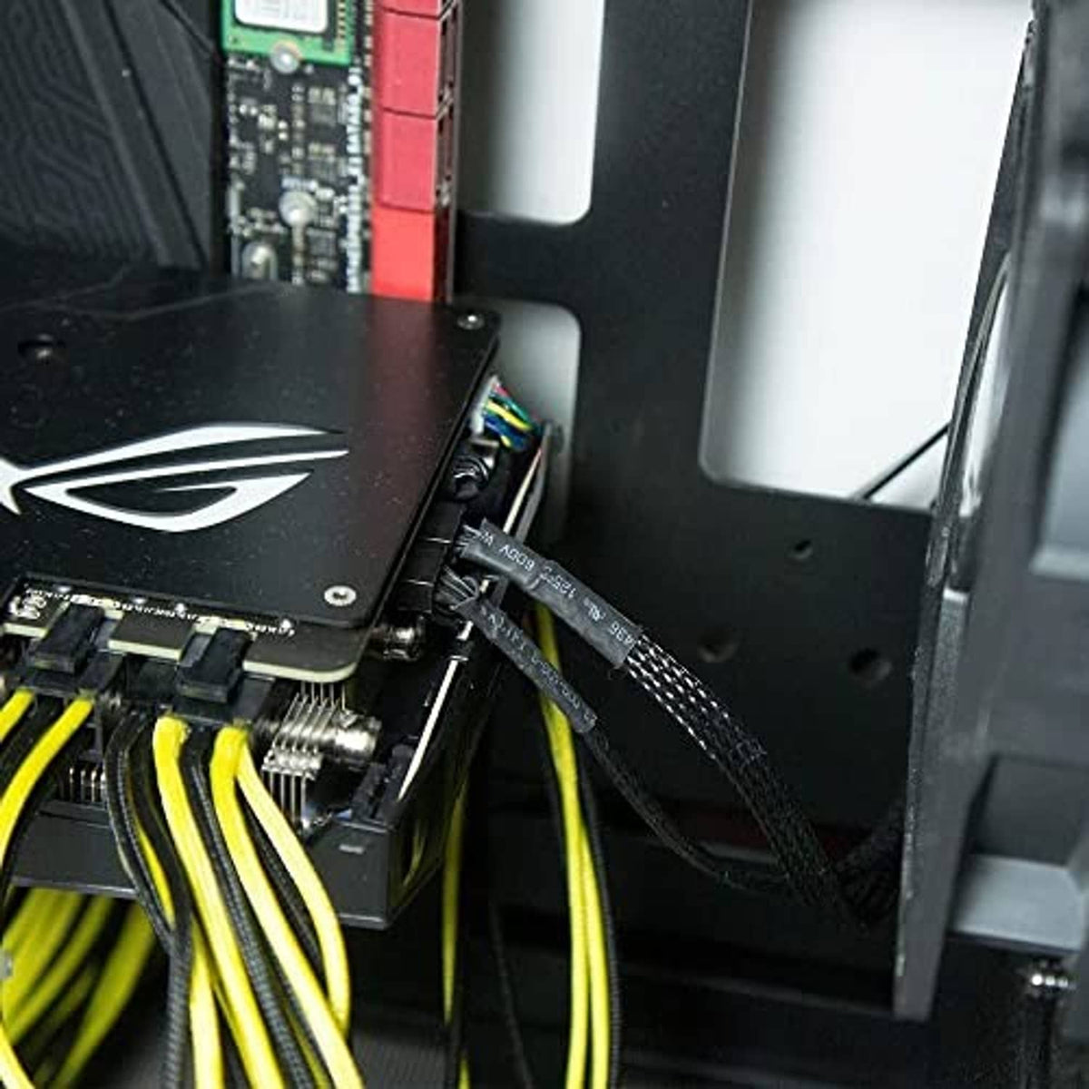 SATA fan power cable plugged into PC case fan header, black braided connection