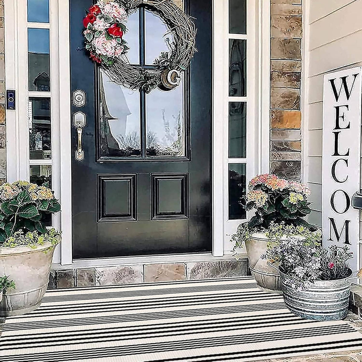 Black-and-white striped outdoor rug with bold horizontal bands, rectangular and flat-woven.
