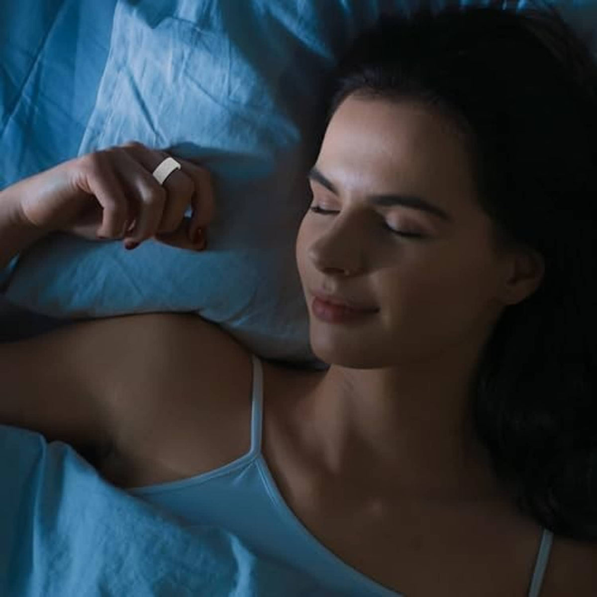 Person resting in bed on a pillow, ring protector case not visible