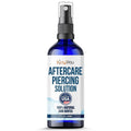 Piercing aftercare saline spray bottle with blue liquid, silver pump, black nozzle