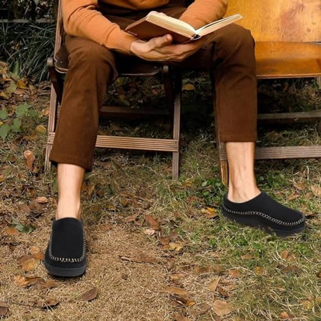 Men's black slip-on moccasin slippers worn with casual pants