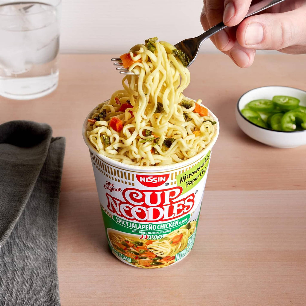 Spicy jalapeno chicken ramen cup filled with noodles held by spoon