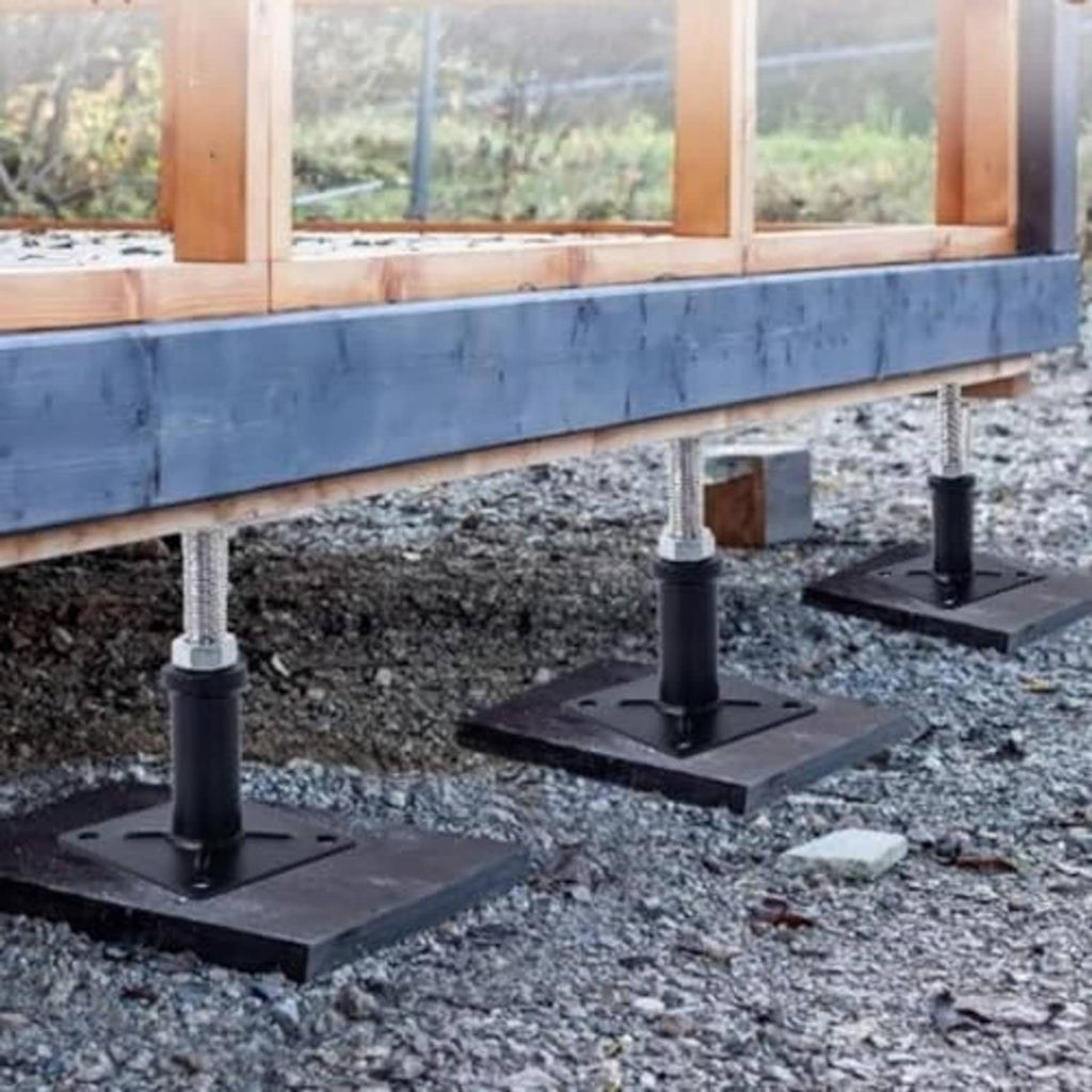 Jack lift support posts installed under wooden frame, black square bases with screws