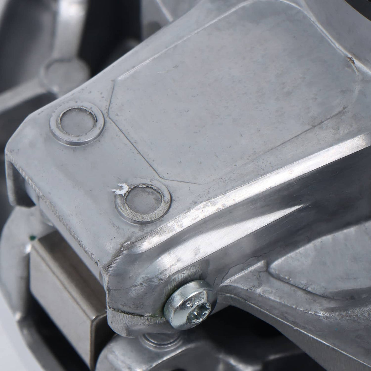 Metal clutch assembly bracket with fasteners and central mounting bolt, close-up