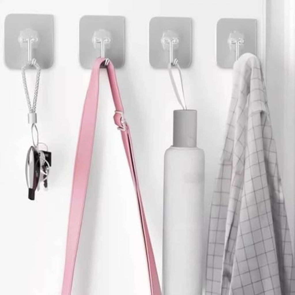 Multiple adhesive wall hooks with chrome metal hooks, holding items on a smooth wall