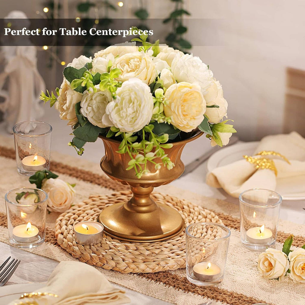 Clear glass candle holders with lit tea lights around a floral centerpiece