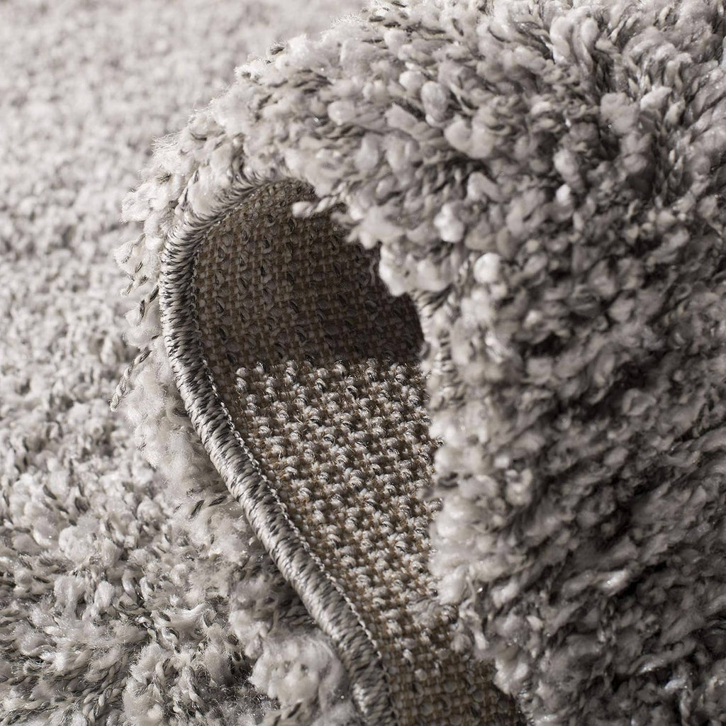 Silver shag rug edge with woven backing and thick loop pile