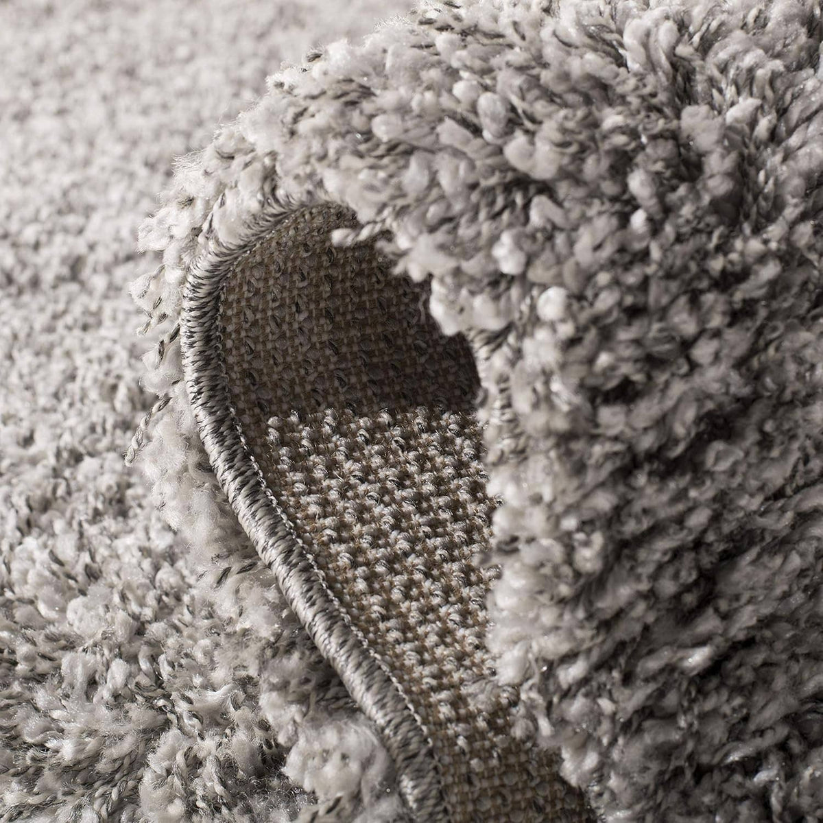 Silver shag rug edge with woven backing and thick loop pile