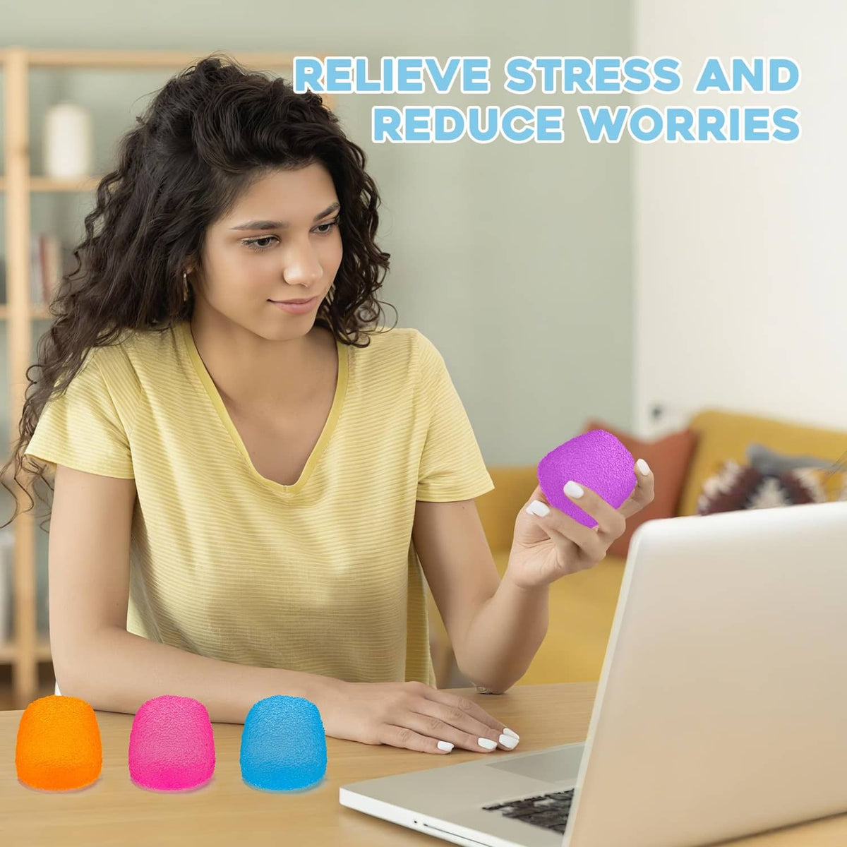 Purple squishy stress ball in a hand with orange, pink, and blue balls nearby
