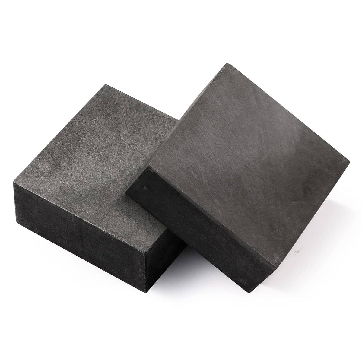 Graphite ingot blocks, dark gray rectangular prisms stacked and overlapping
