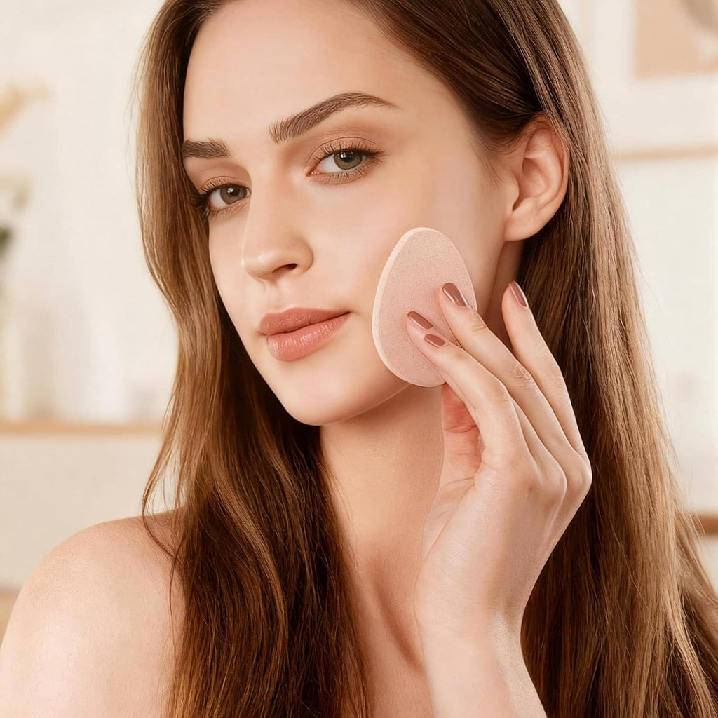 Beige teardrop makeup sponge pressed on cheek for foundation application