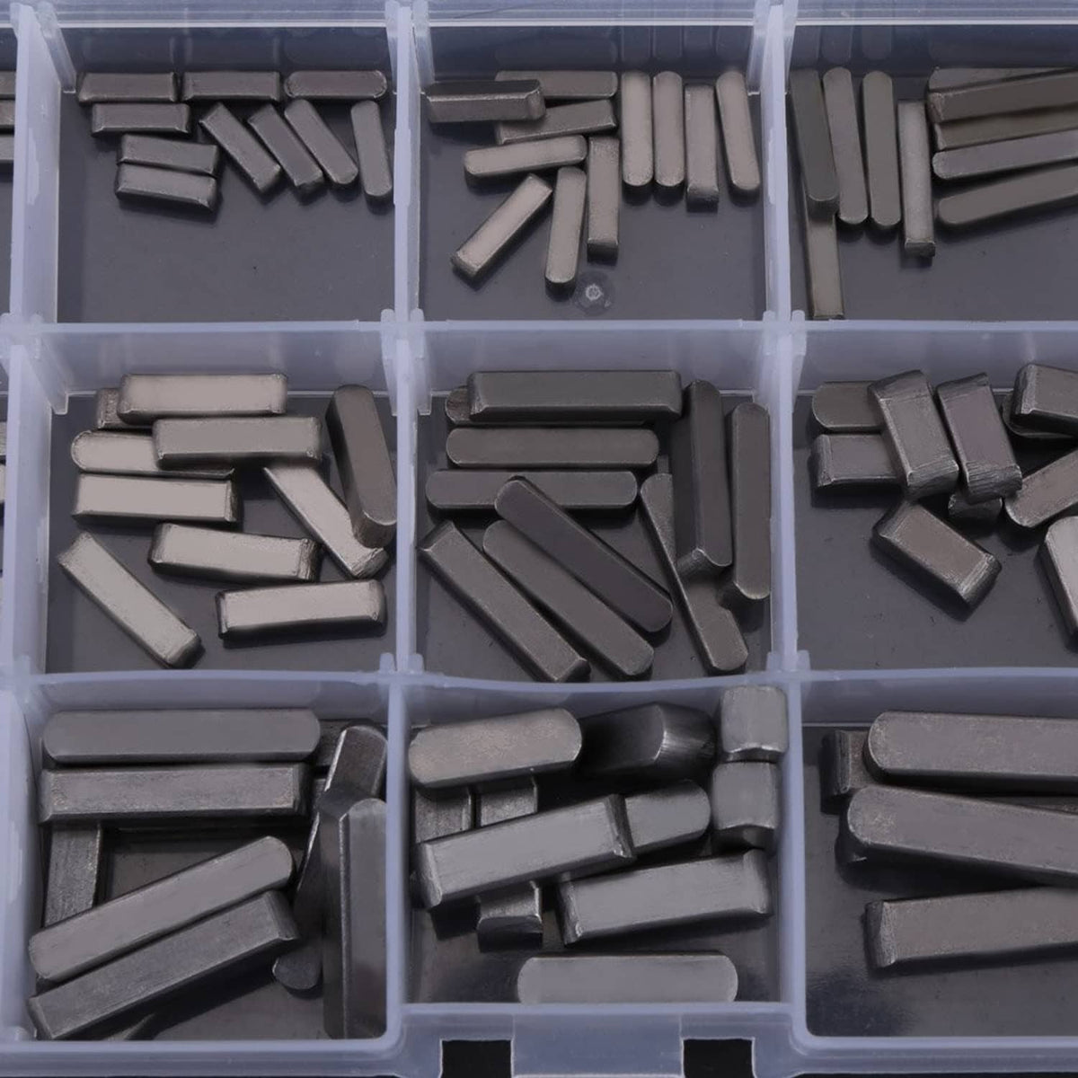 Close-up of dark key stock pieces in organizer compartments, various rectangular shapes