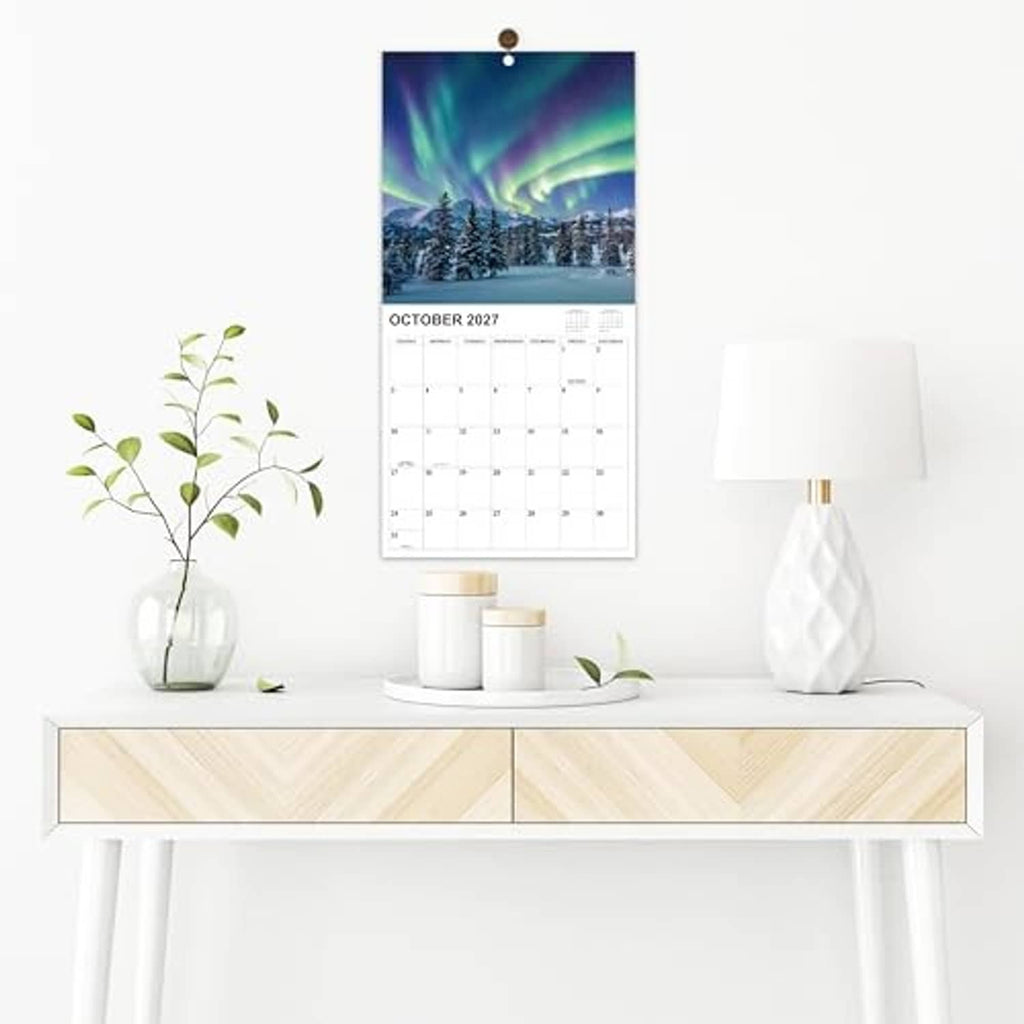 Aurora-themed wall calendar page hanging, showing October 2027 monthly date grid