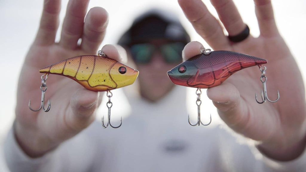 Two crankbaits held up: yellow-orange and red bodies with treble hooks