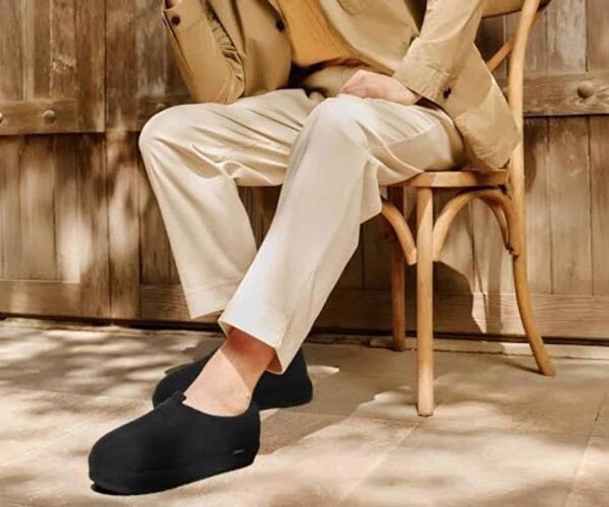 Black slip-on clog slippers worn on feet, plush-lined interior