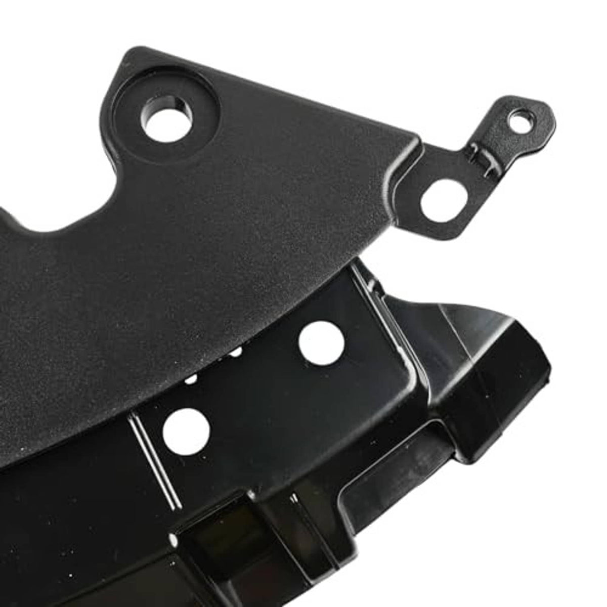 Front bumper grille retainer bracket, black plastic close-up with large bolt hole and metal tab