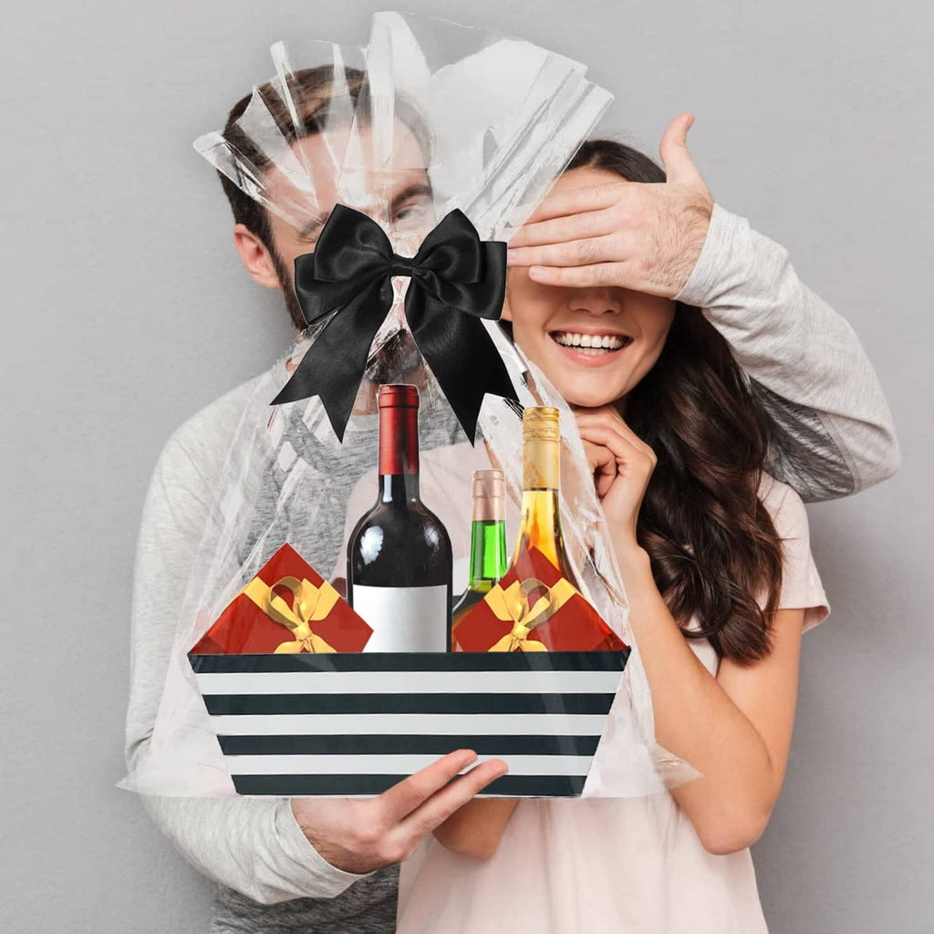 Black and white striped gift basket with black bow and tulle wrap, held by two people
