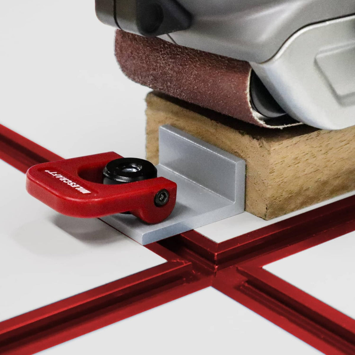Red T-track cam stop close-up with black knob, mounted on metal T-slot rail