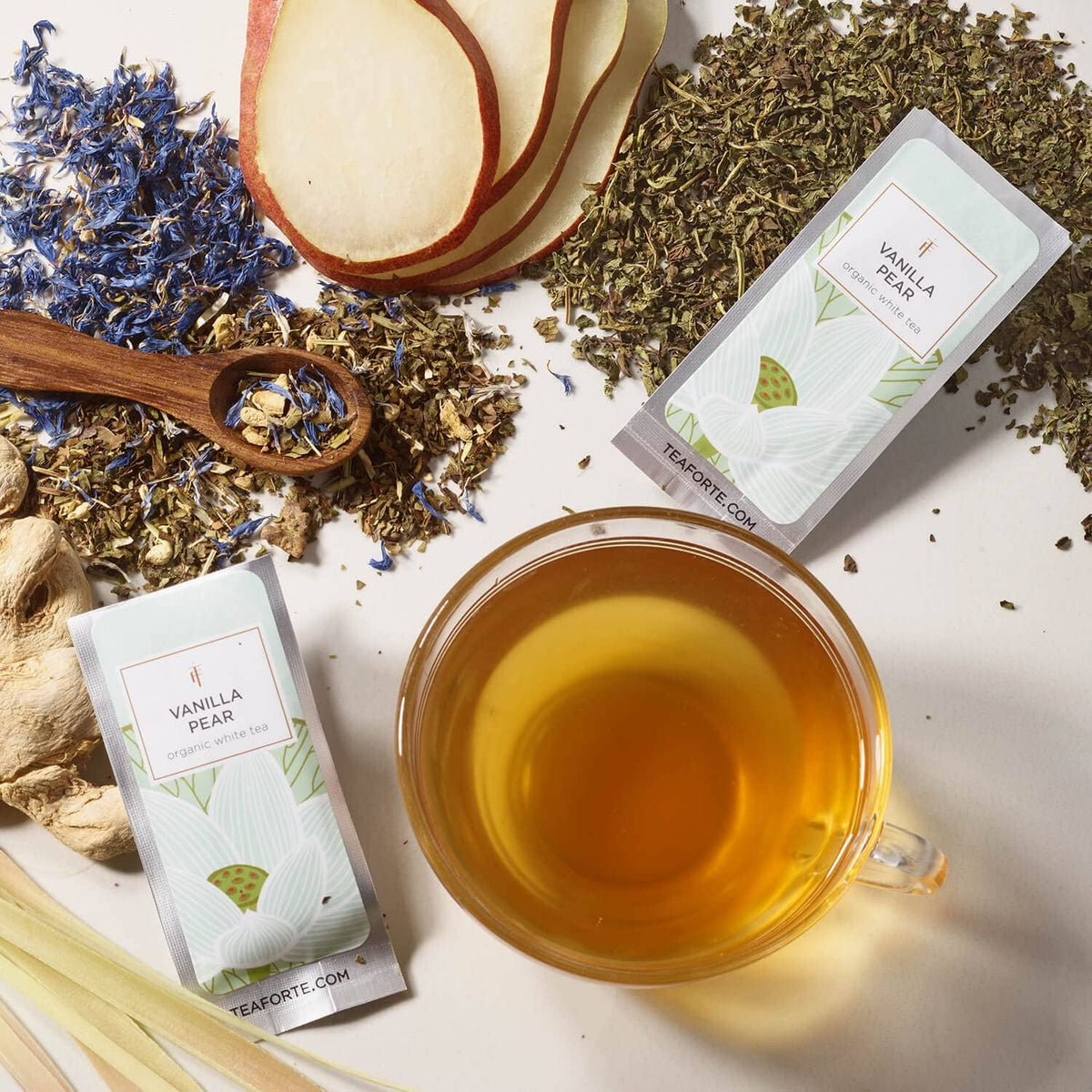 Vanilla Pear loose leaf tea with a cup of brewed tea and labeled sampler pouch