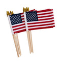 Two small US flags on wooden sticks with gold spear tips