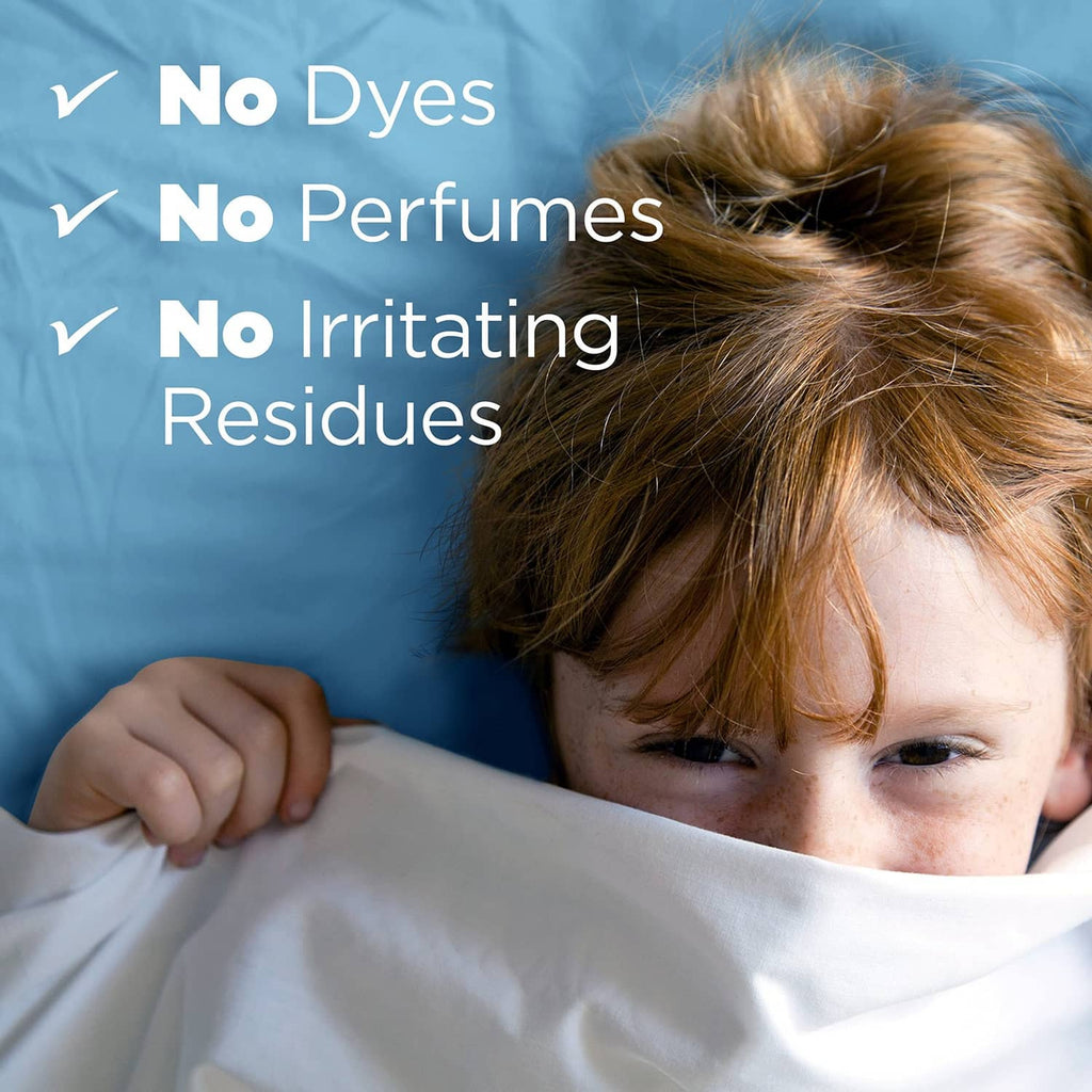 Laundry detergent pods; child resting on white bedding fabric
