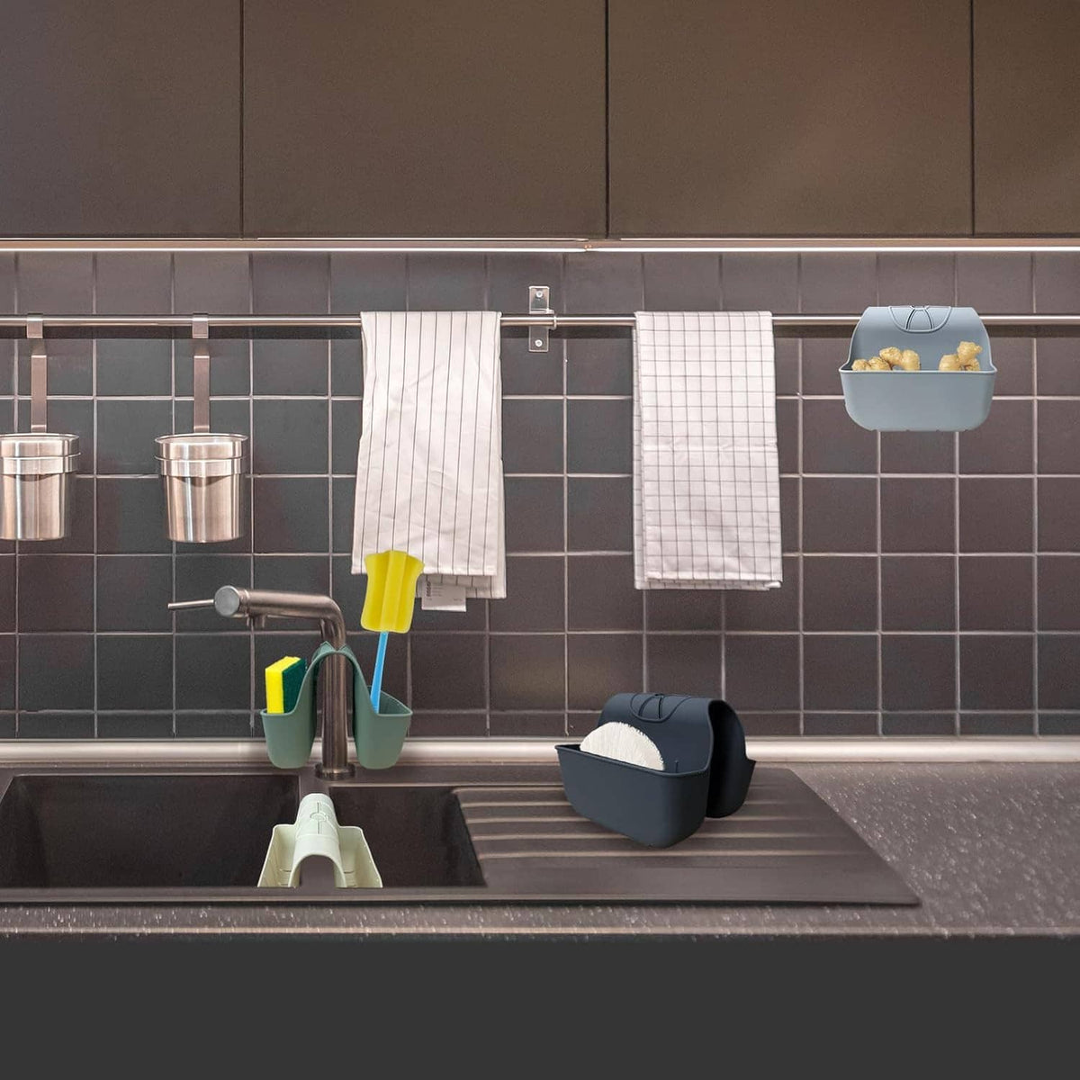 Gray silicone sink sponge caddy installed on sink edge with utensils