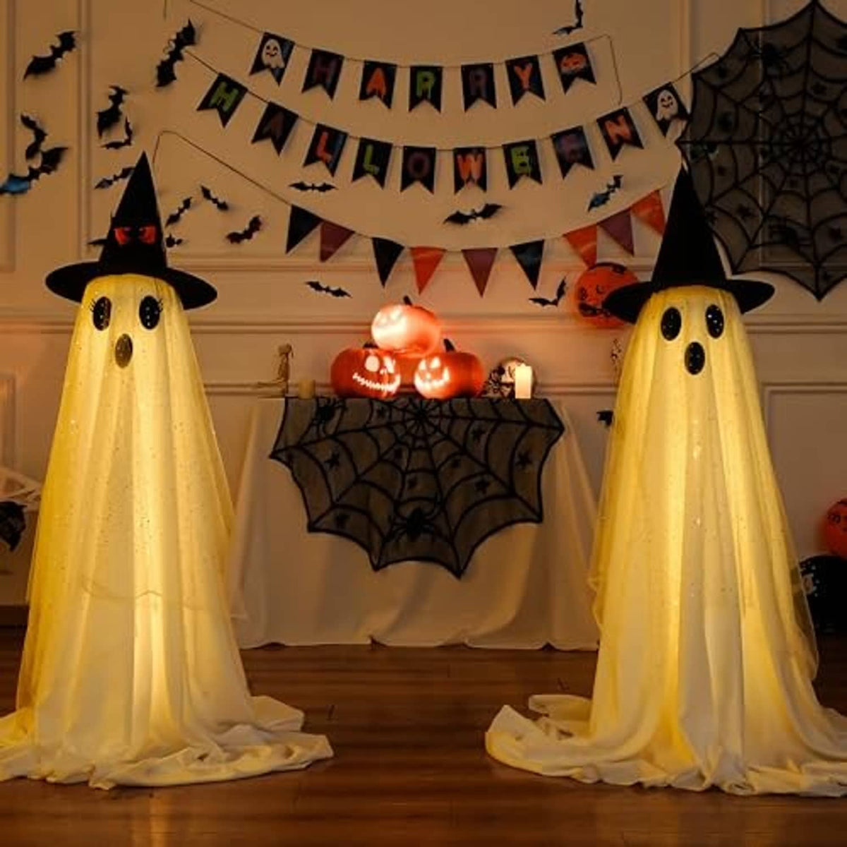 Two standing ghost decorations with black hats and dotted faces, flowing yellow glow and sheer drape.
