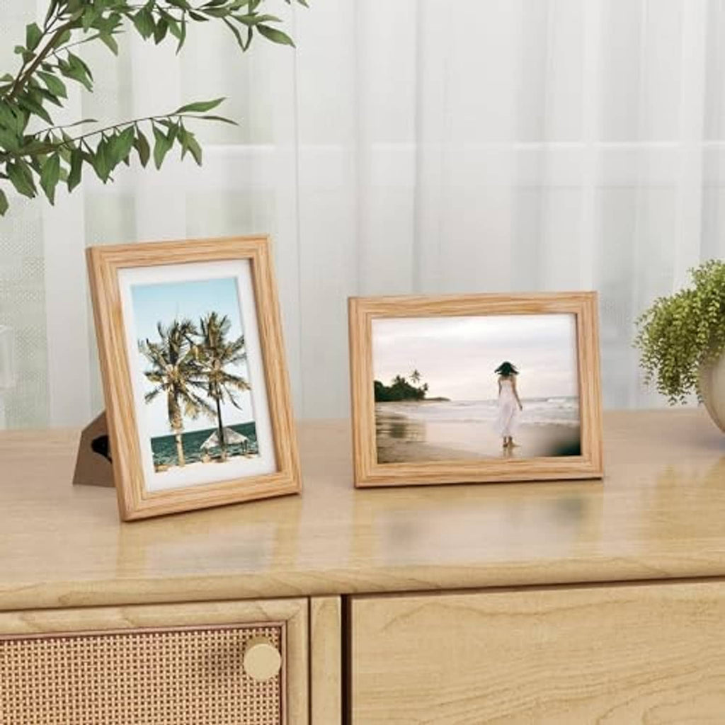 Two oak 5x7 picture frames on a table, displaying photos with glass fronts