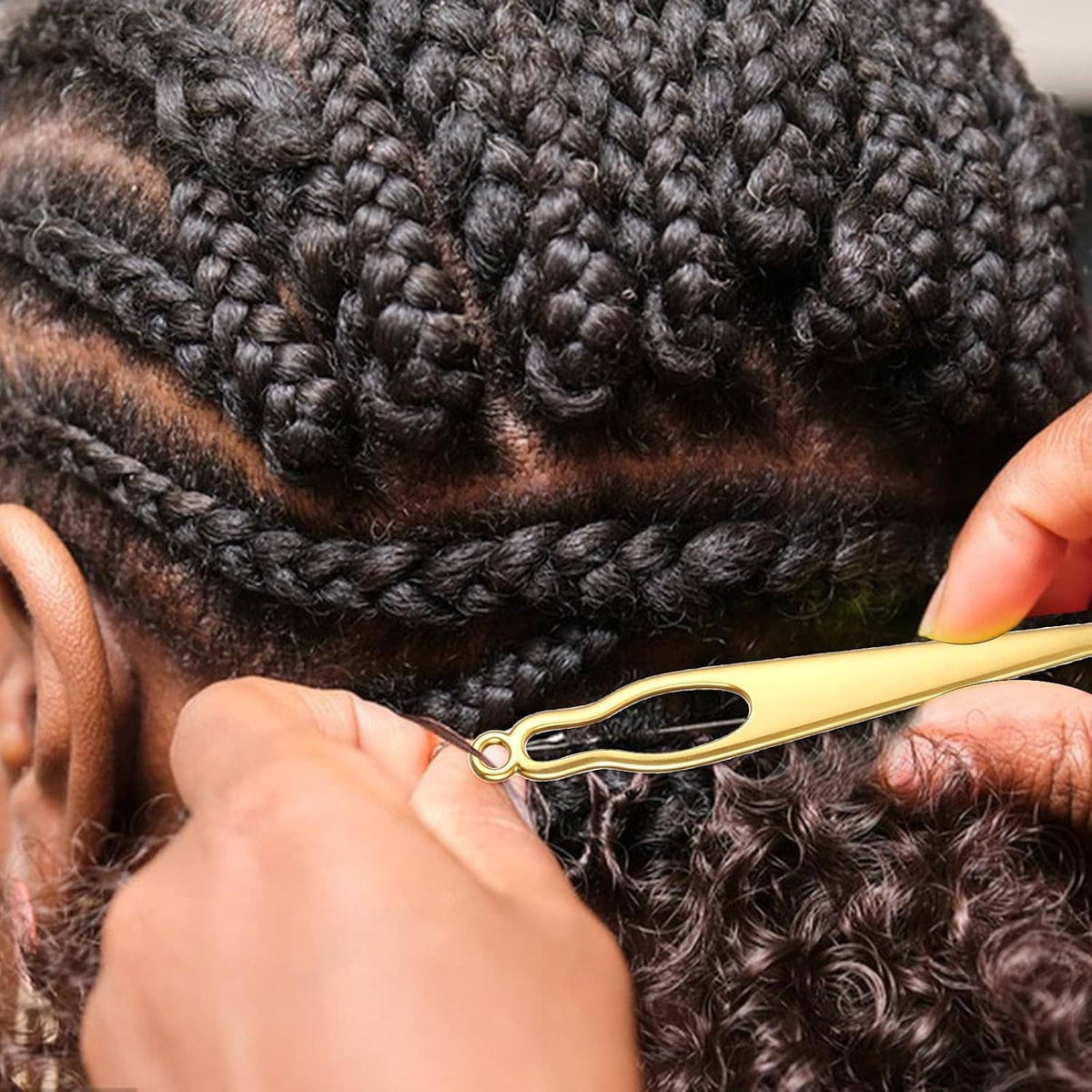 Gold crochet hook needle used on black dreadlocks, with looped tip