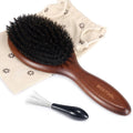 Oval hair brush with dark bristles and brown wooden handle, with drawstring cover bag