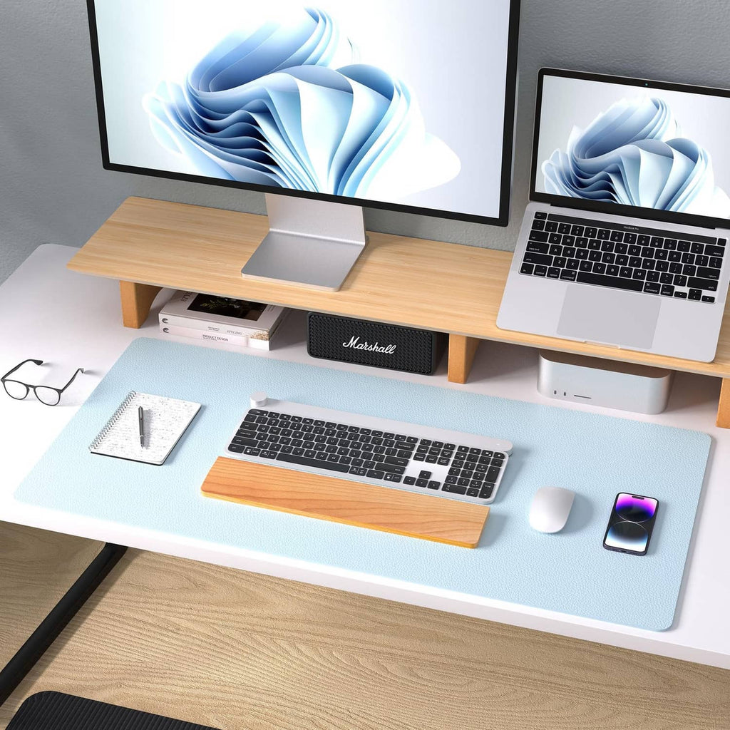 Baby blue leather desk pad protector under a laptop keyboard and mouse on a desk