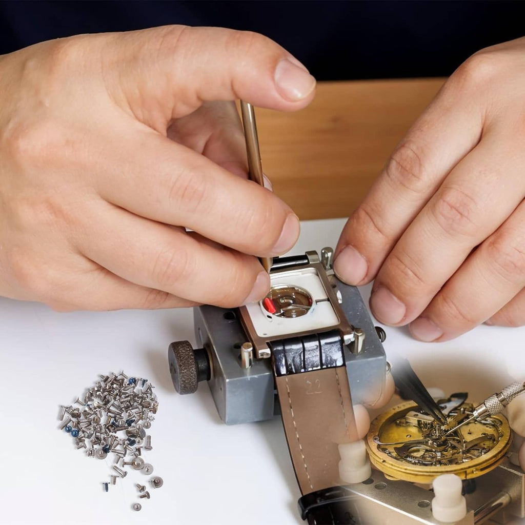 Watch battery clamp screw assortment in repair: screws, watch parts, and hands using tool