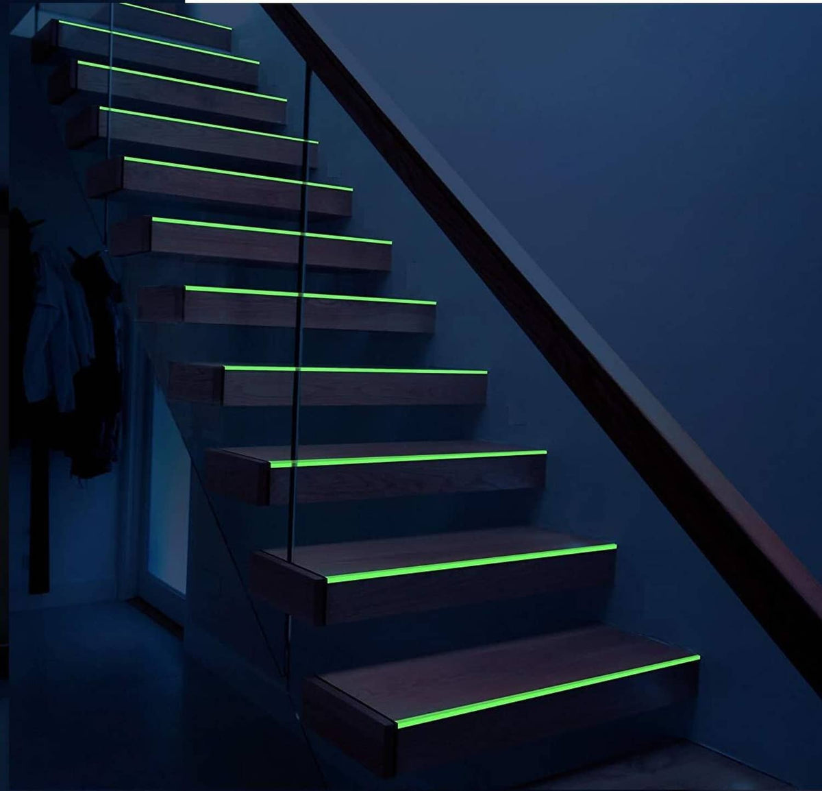 Fluorescent glow tape outlining staircase steps with bright green luminous lines