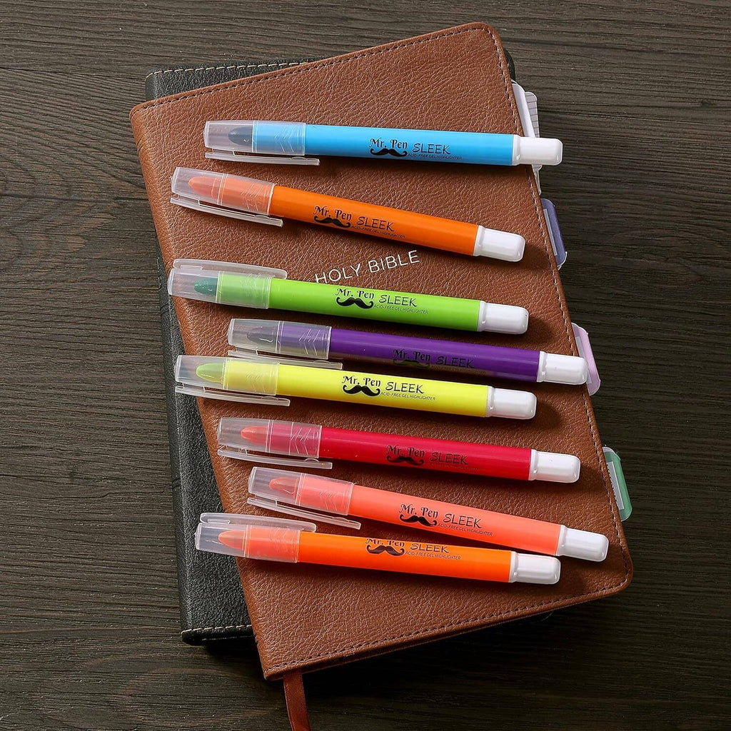 Assorted gel highlighters laid across notebooks, twist-up pens in multiple colors