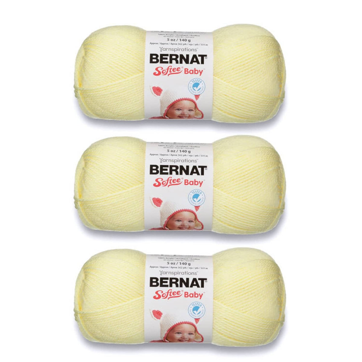 Three pale yellow baby yarn skeins with BERNAT Softee Baby labels