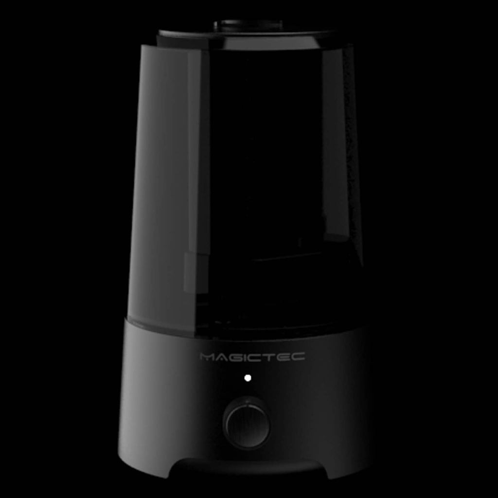 Black cool mist humidifier shown in low light with front control knob