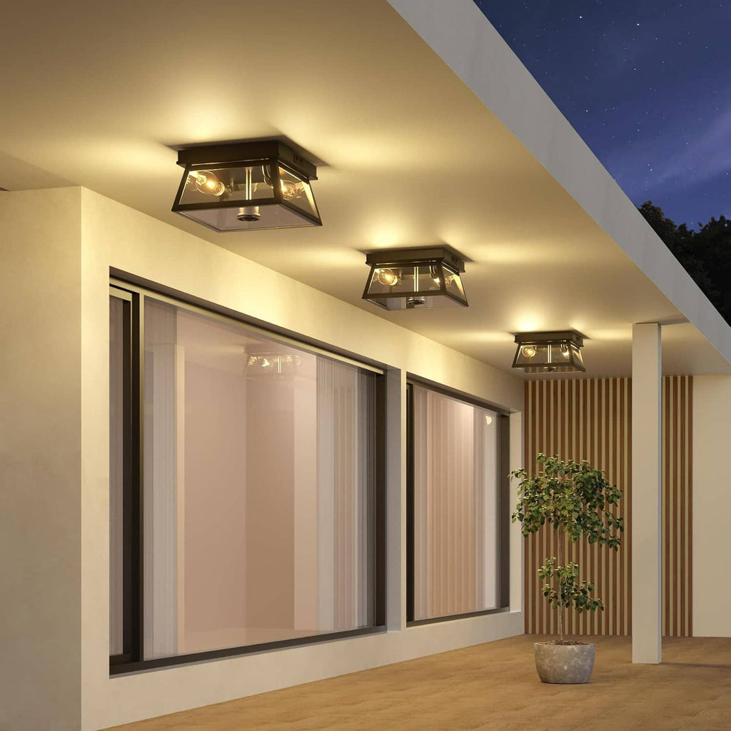 Black outdoor flush mount ceiling light installed along a covered porch corridor