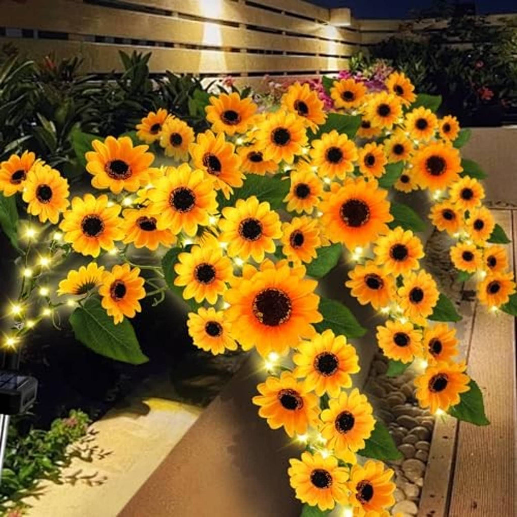 Solar sunflower garden lights with warm white glowing LEDs and green leaves