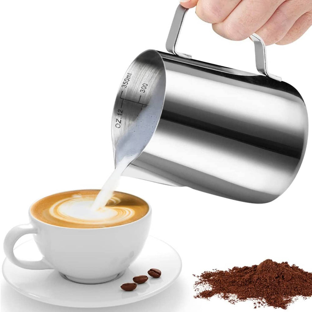 Stainless steel frothing pitcher pouring milk into a cup, with side spout and handle