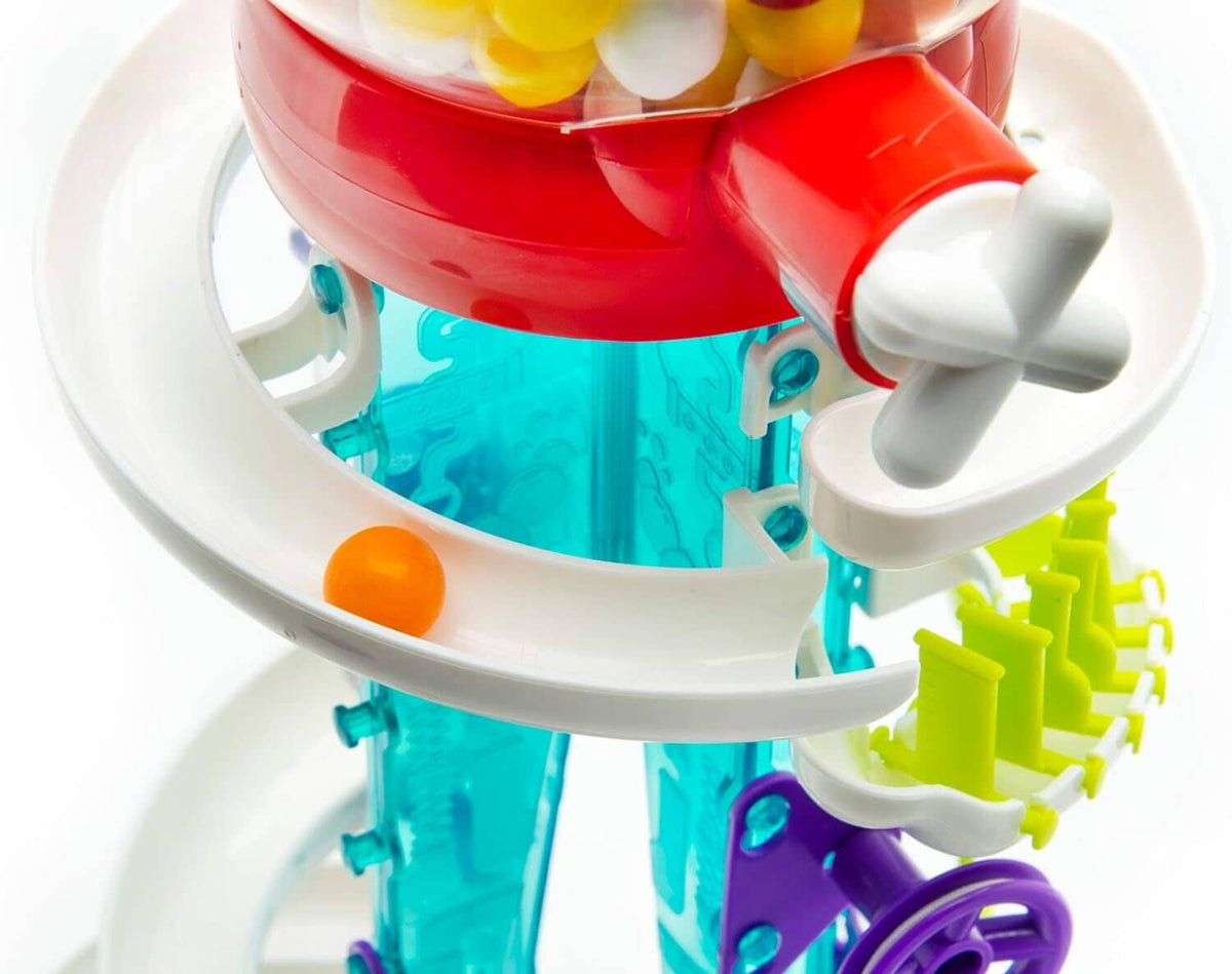 Close-up of gumball machine top with red rotating part and light-blue basin.