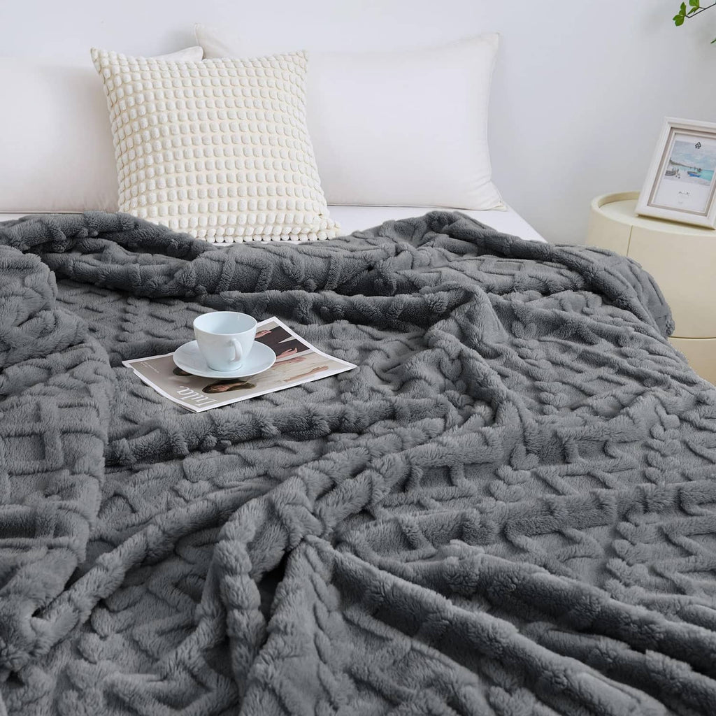 Gray fuzzy king-size blanket spread on bed, plush raised texture