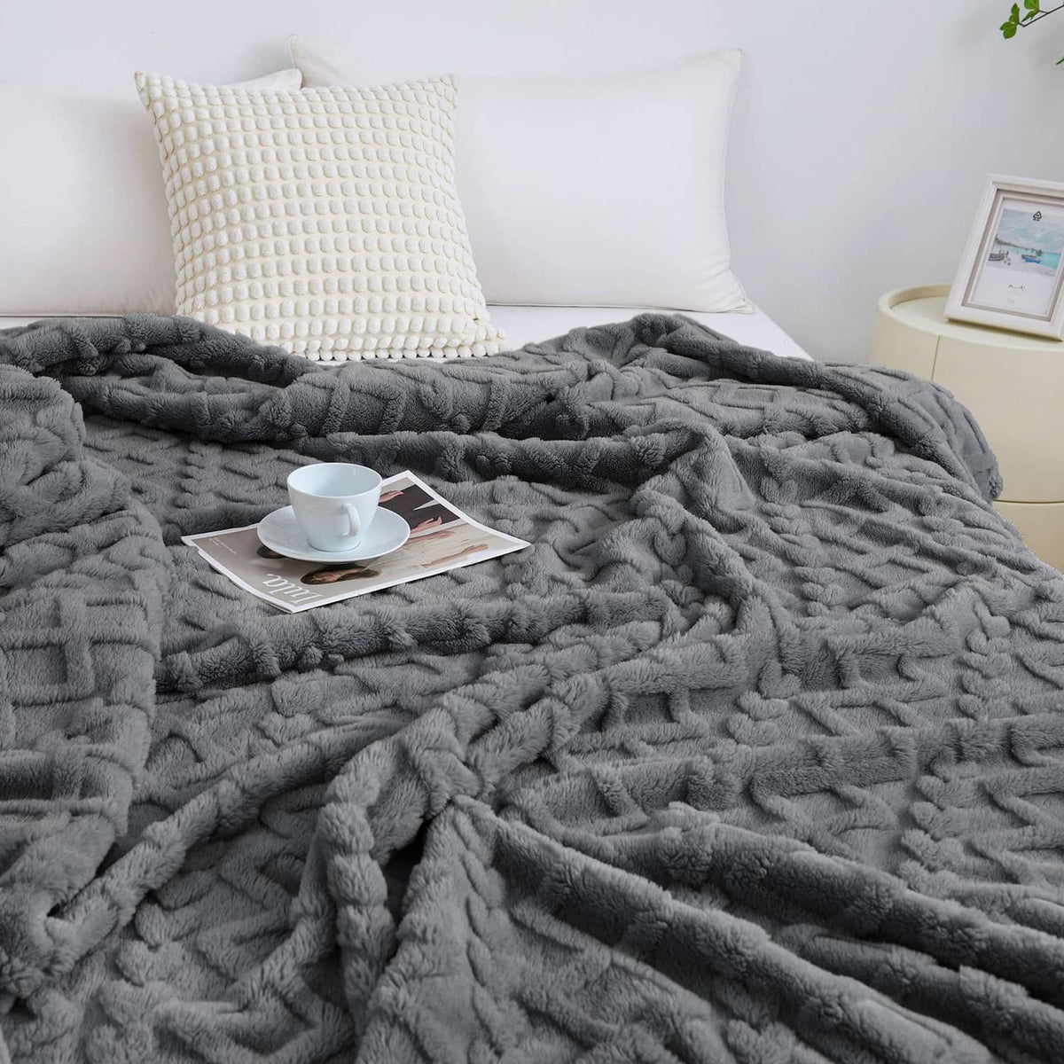 Gray fuzzy king-size blanket spread on bed, plush raised texture